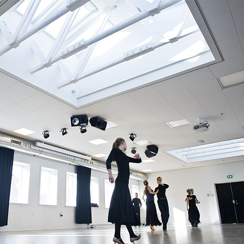 Dancers rehearsing underneath large skylights
